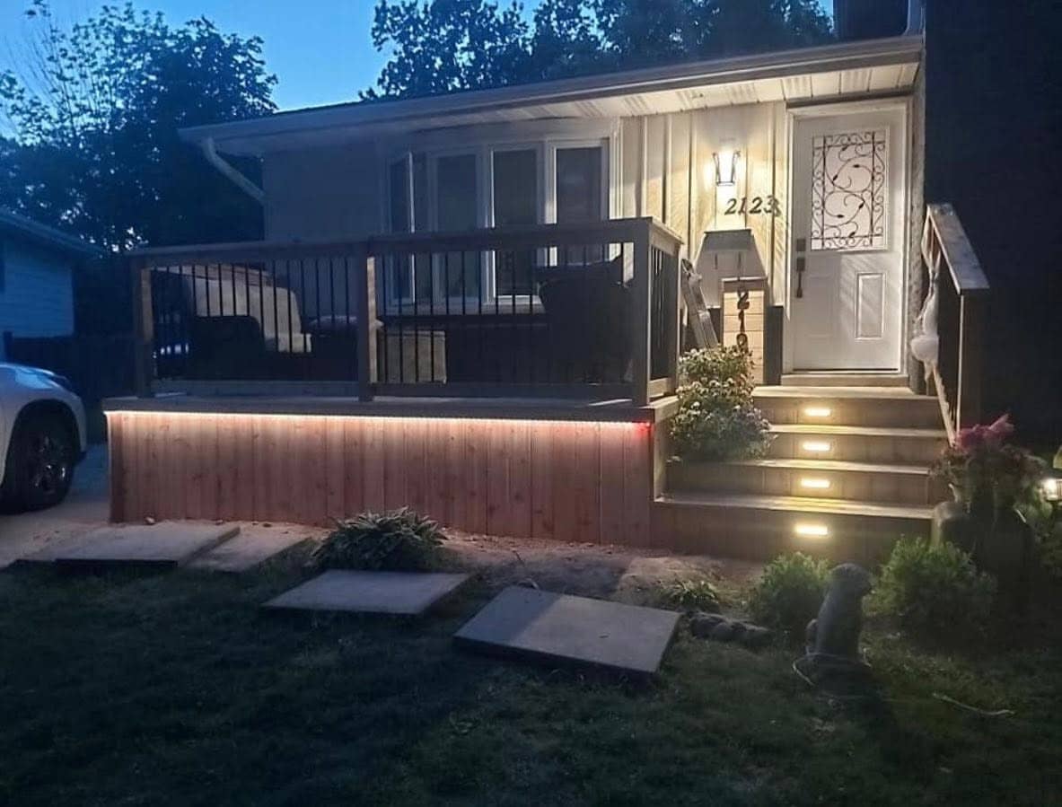 Low cedar deck with warm under-rail lighting at dusk