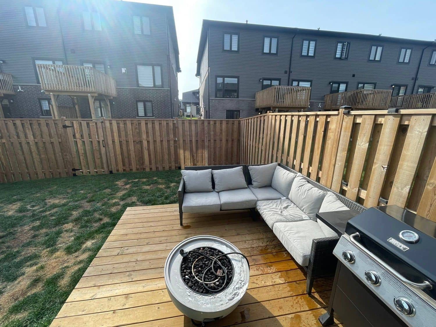 New backyard deck with a sectional lounge and fire bowl