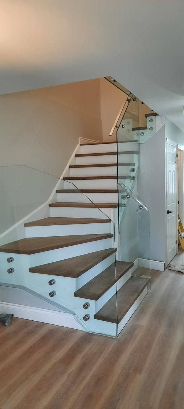 Floating hardwood staircase with a frameless glass railing